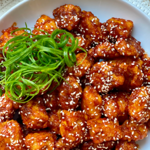 korean fried chicken bites with spring onion garnish