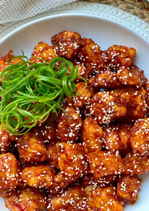 korean fried chicken bites with spring onion garnish